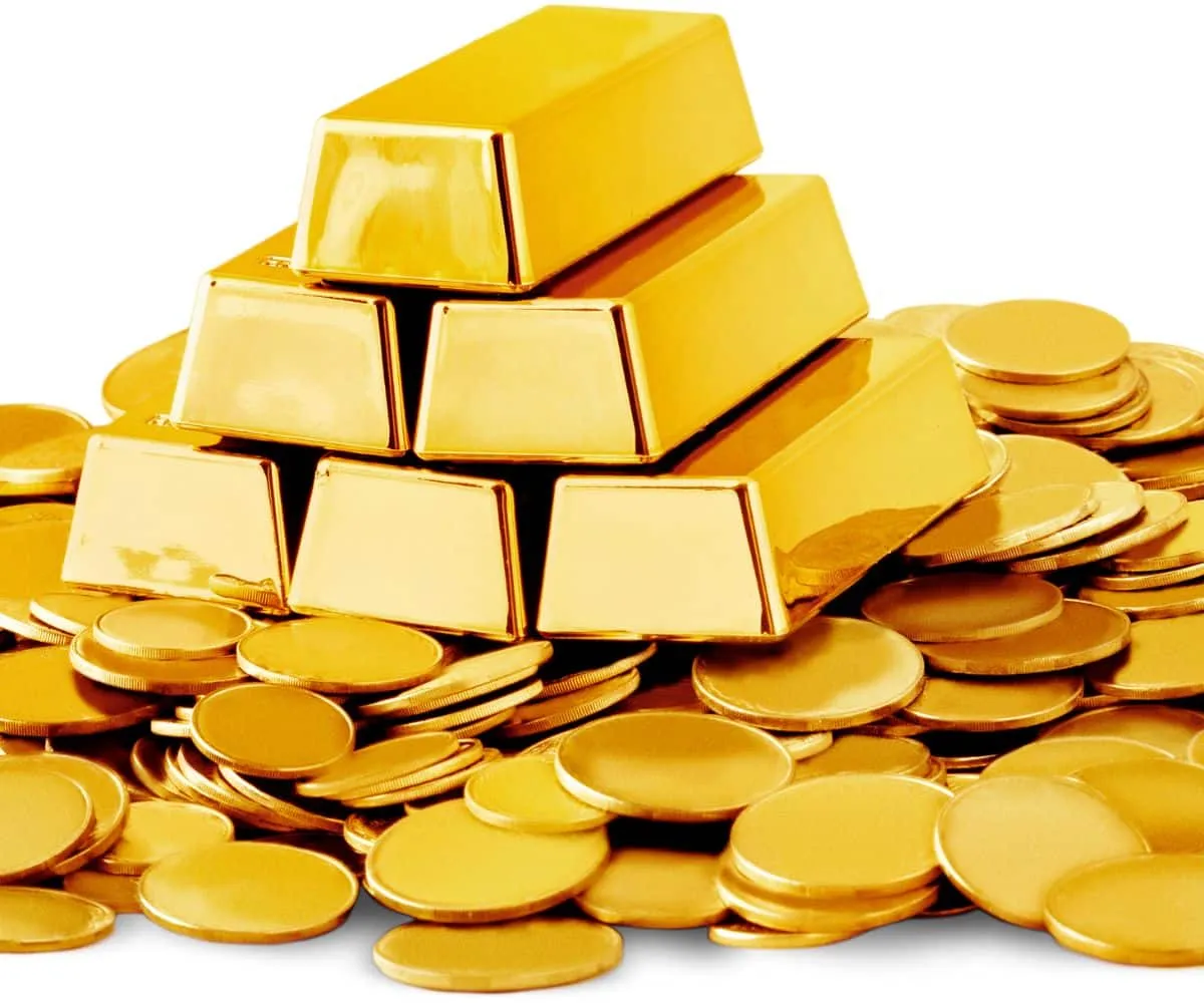 Une main tenant une balance avec des pièces d'or et des bijoux, symbolisant l'optimisation des revenus grâce au rachat d'or à Paris.
